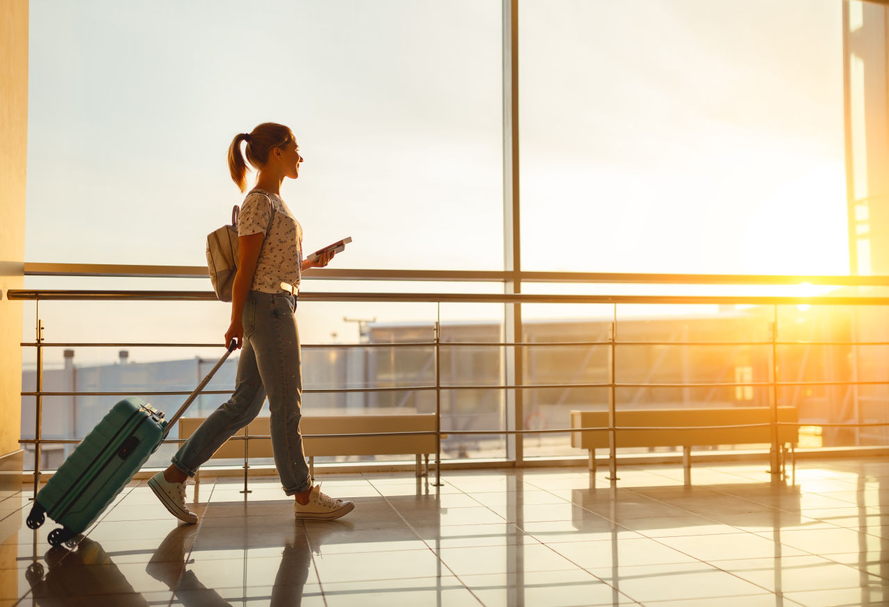 A woman walking with luggage through an airport